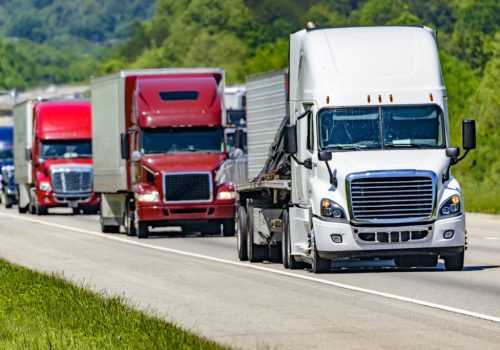 A,Solid,Line,Of,Eighteen-wheelers,Barrel,Down,An,Interstate,Highway